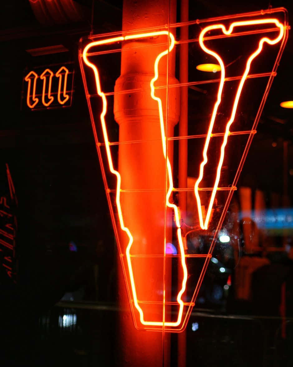 A Neon Sign With A Letter V Wallpaper