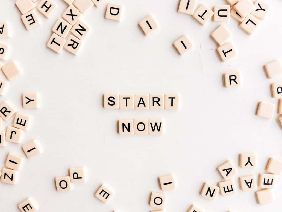 Scrabble Letters Arranged In A Circle With The Word Start Now