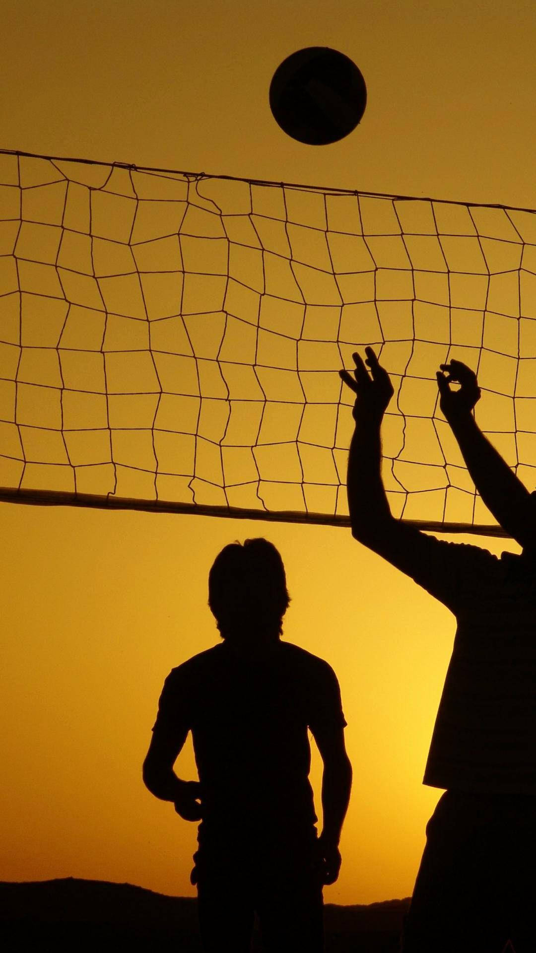 Silhouette Of Two People Playing Volleyball Wallpaper