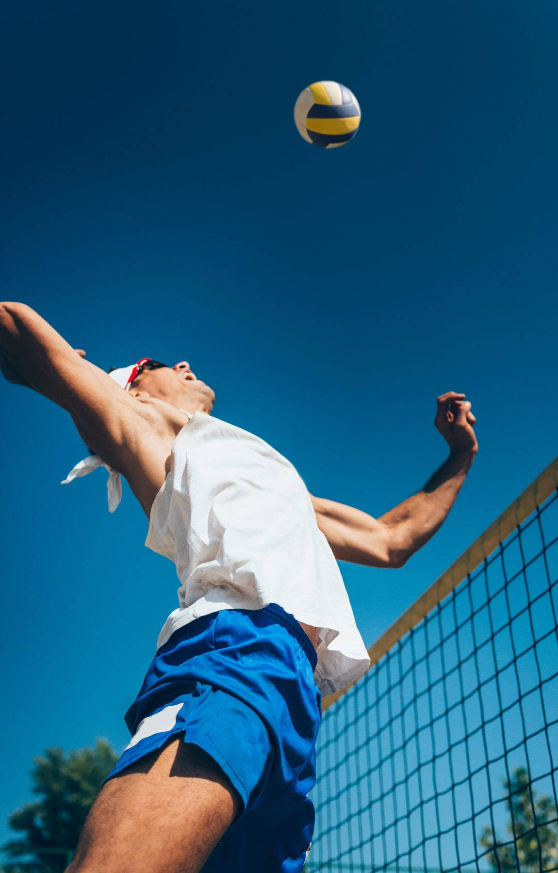 A Man Is Hitting A Volleyball Ball Wallpaper