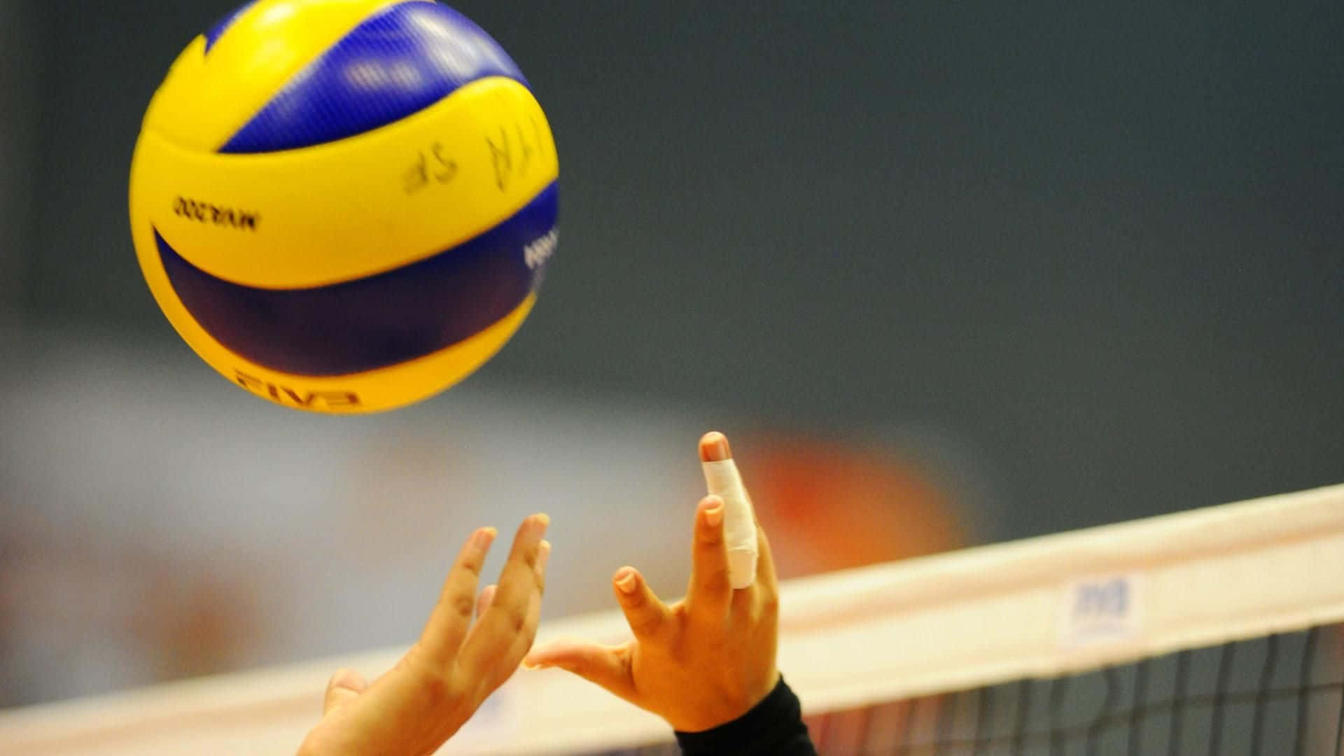 A Person Catching A Volleyball Ball In A Game