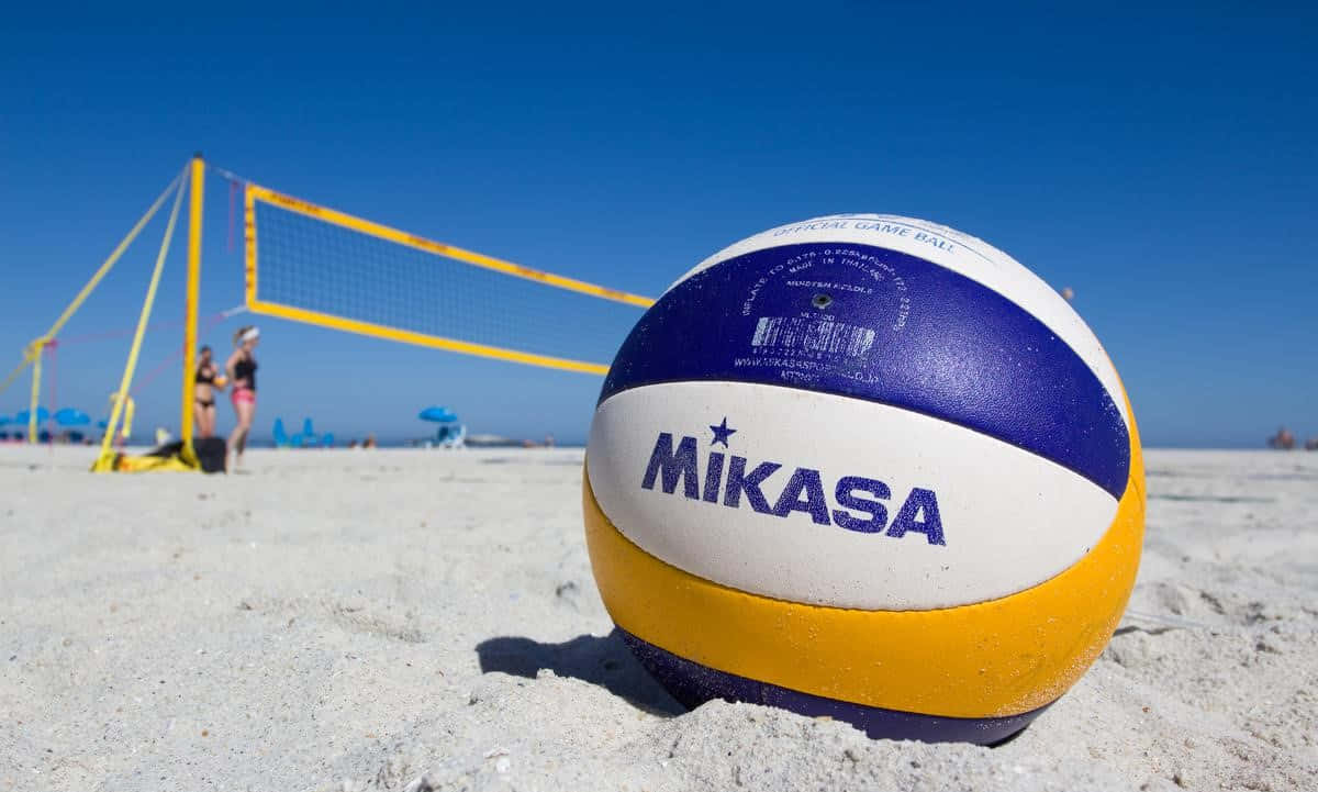 A volleyball is seen in front of a brightly illuminated net