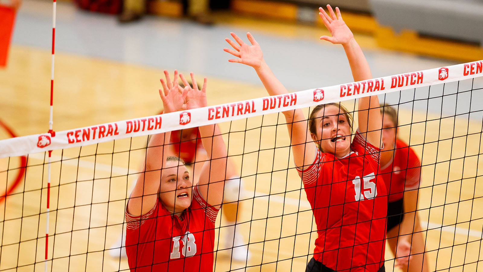 Two Girls In Red Uniforms Are Playing Volleyball Wallpaper