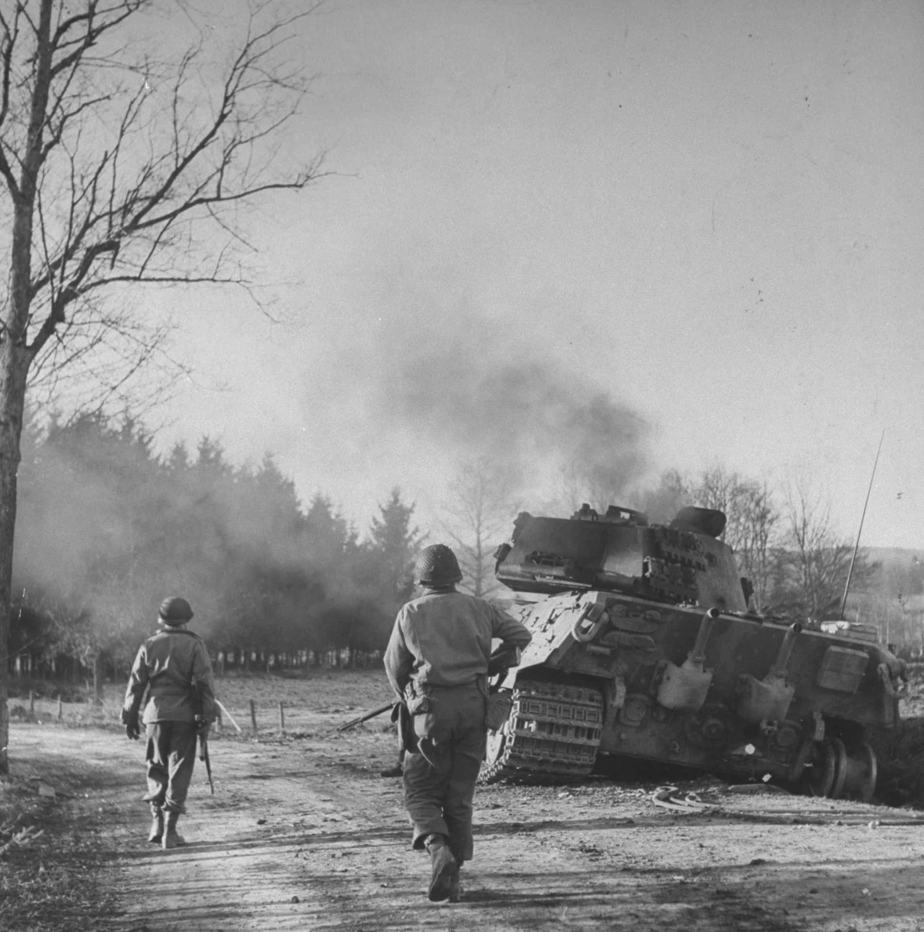 W W2 Soldiers Advancing Past Destroyed Tank Wallpaper