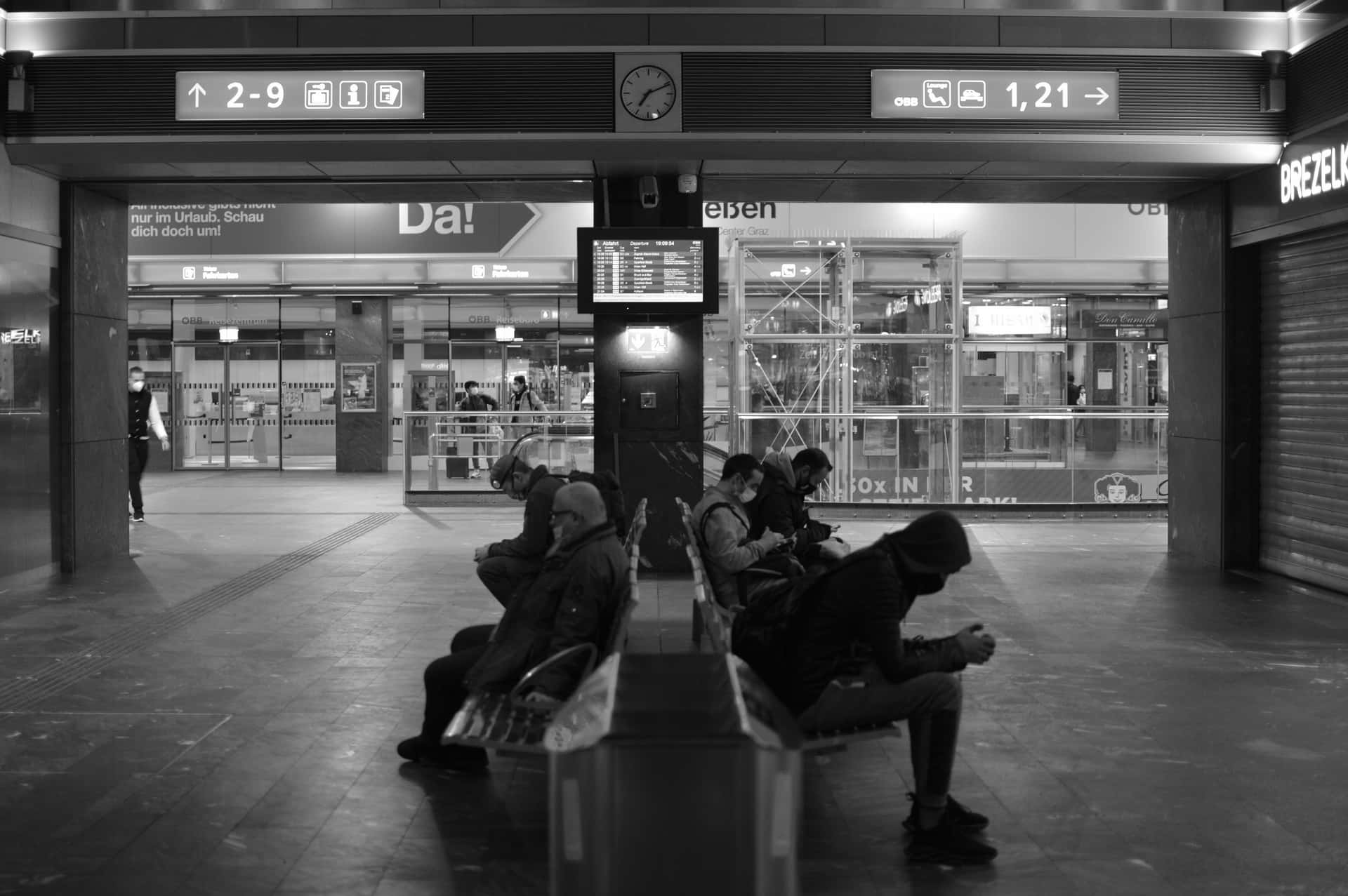 People Sitting On Benches In A Train Station