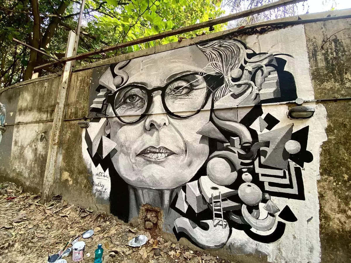 A Woman In Glasses Is Painted On A Wall