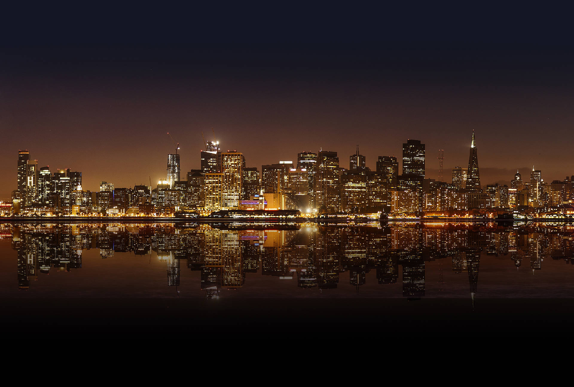 A Panoramic View of the Colorful Lights of San Francisco at Night Wallpaper