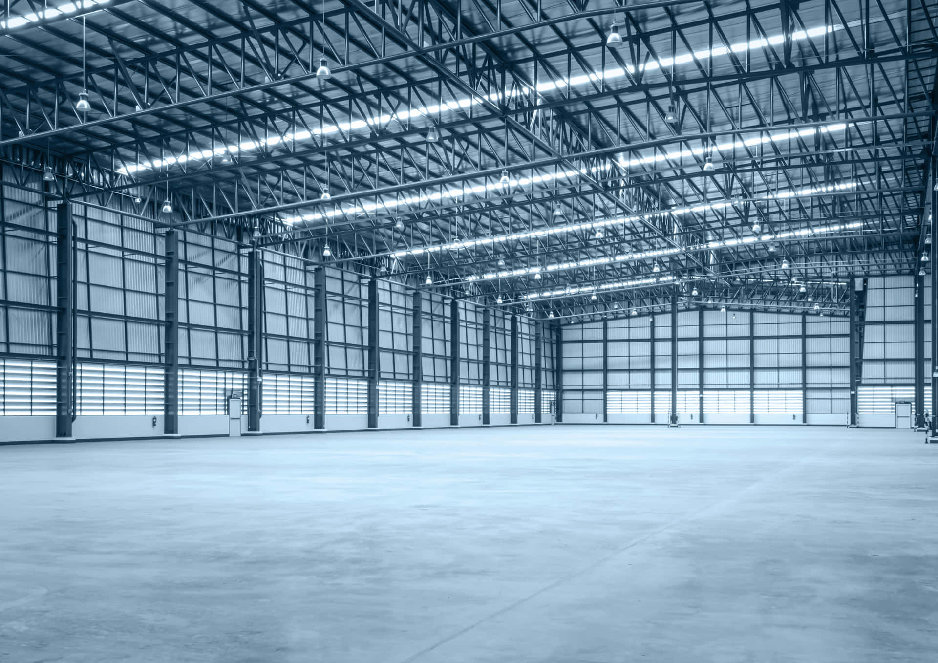 A Large Warehouse With Blue Walls And Concrete Floor