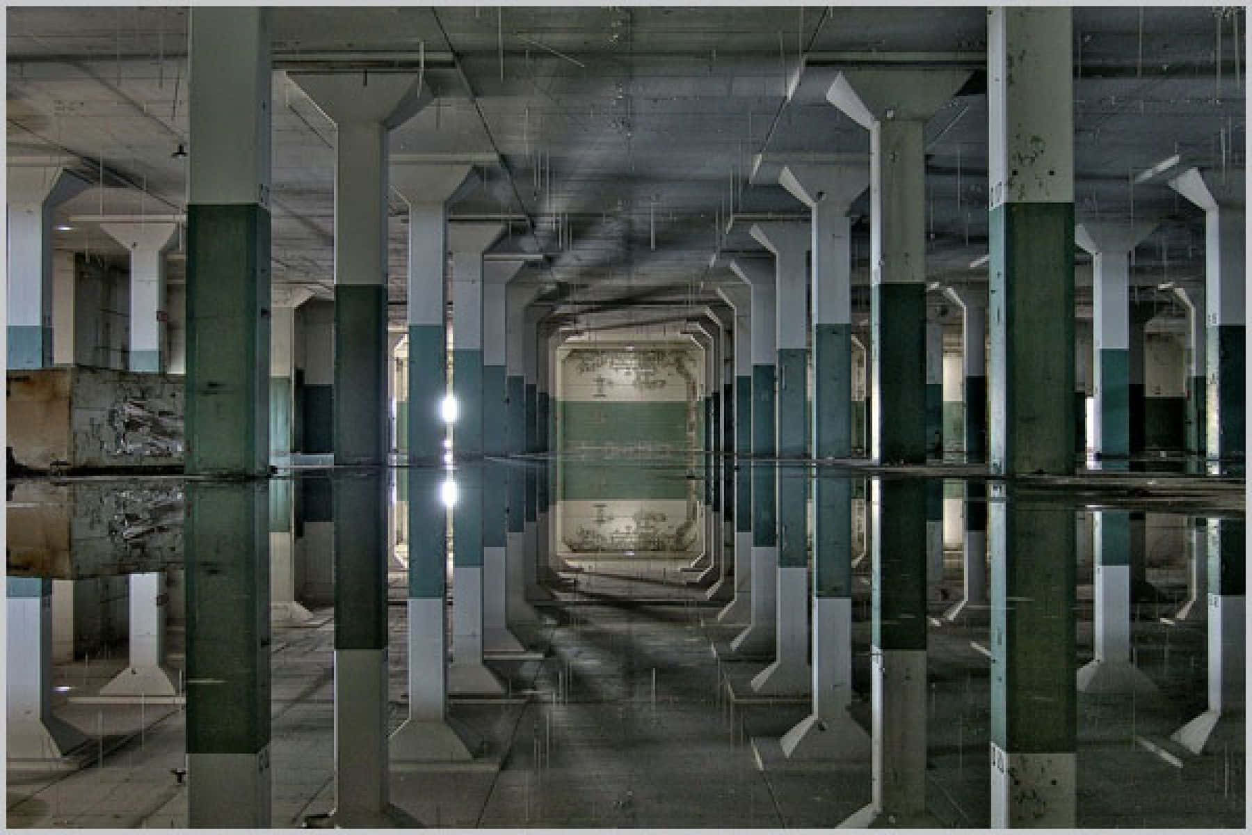 A Large Building With Columns And Water Reflected In It