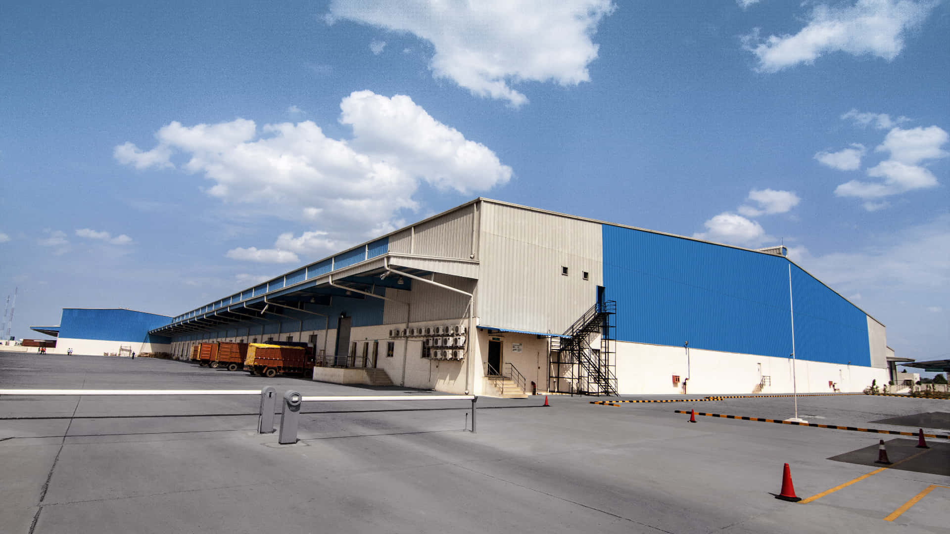A Large Warehouse With Blue Walls And A Blue Sky