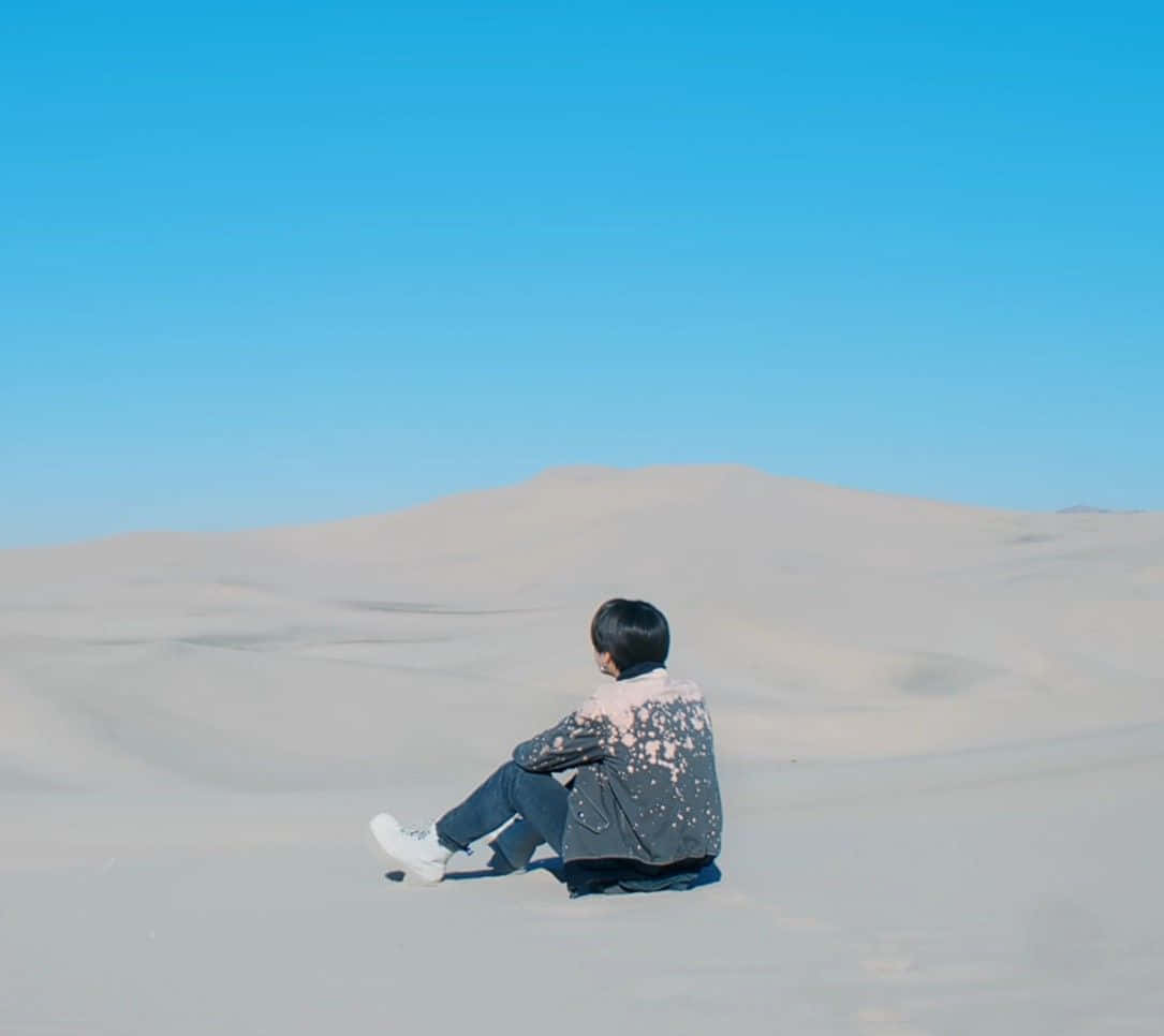 Unuomo Seduto Sulle Dune Di Sabbia