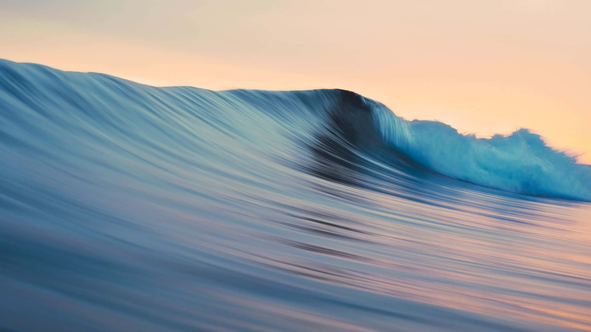 A Wave Is Breaking On The Ocean At Sunset Wallpaper