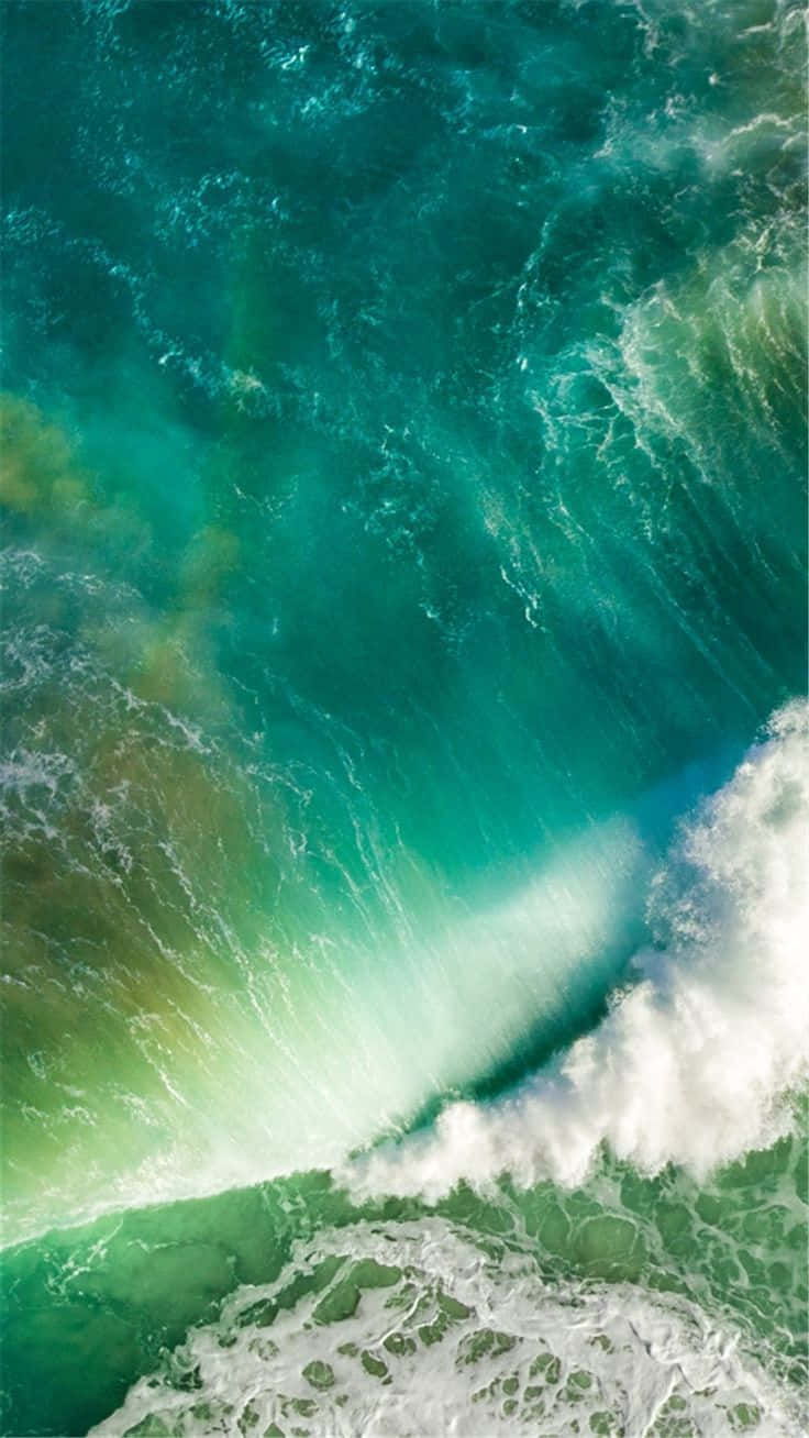En grøn bølge knuses mod havet nedenunder Wallpaper