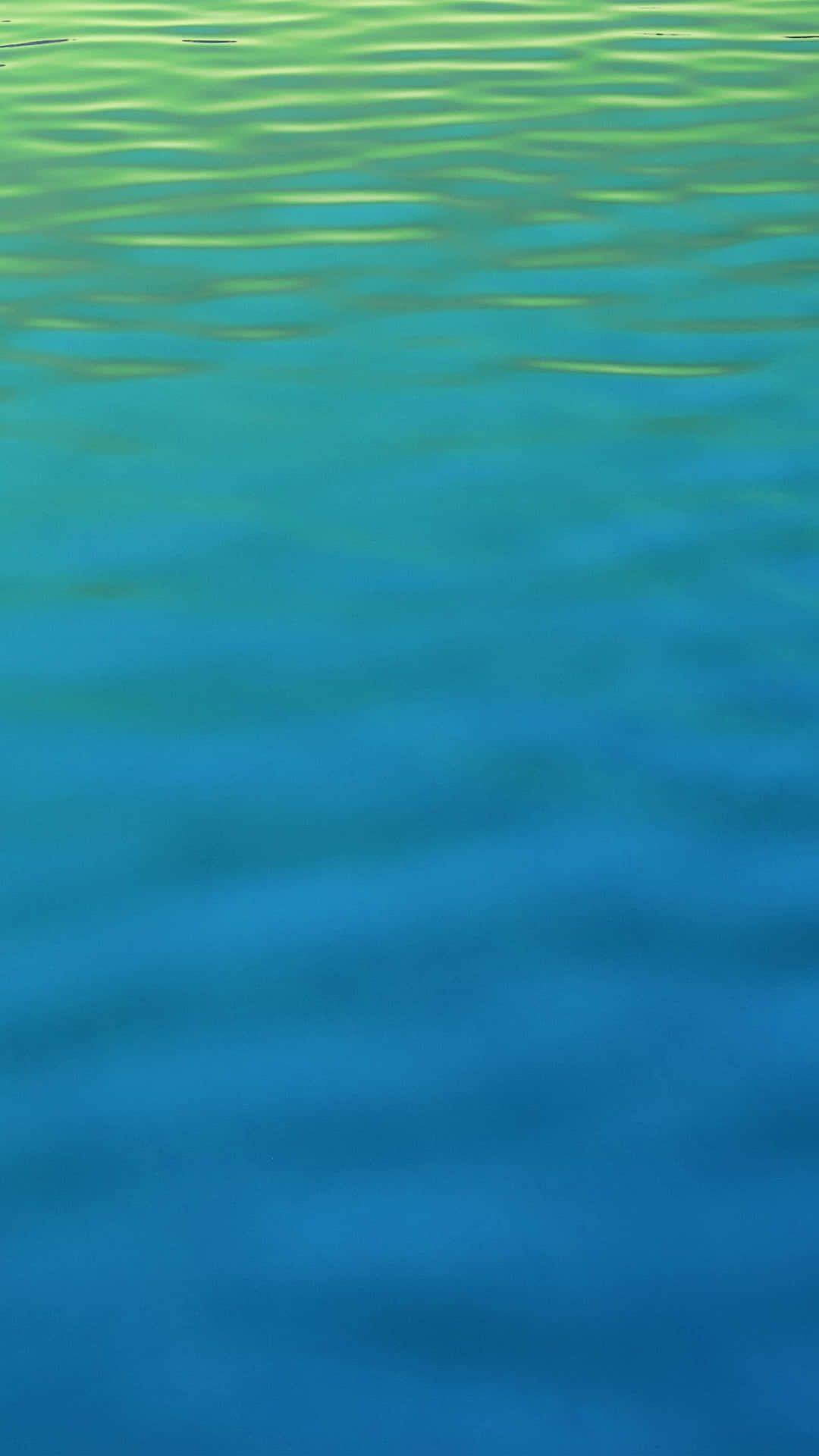 En blå og grøn vand med bølger af solskin, der reflekterer over det. Wallpaper