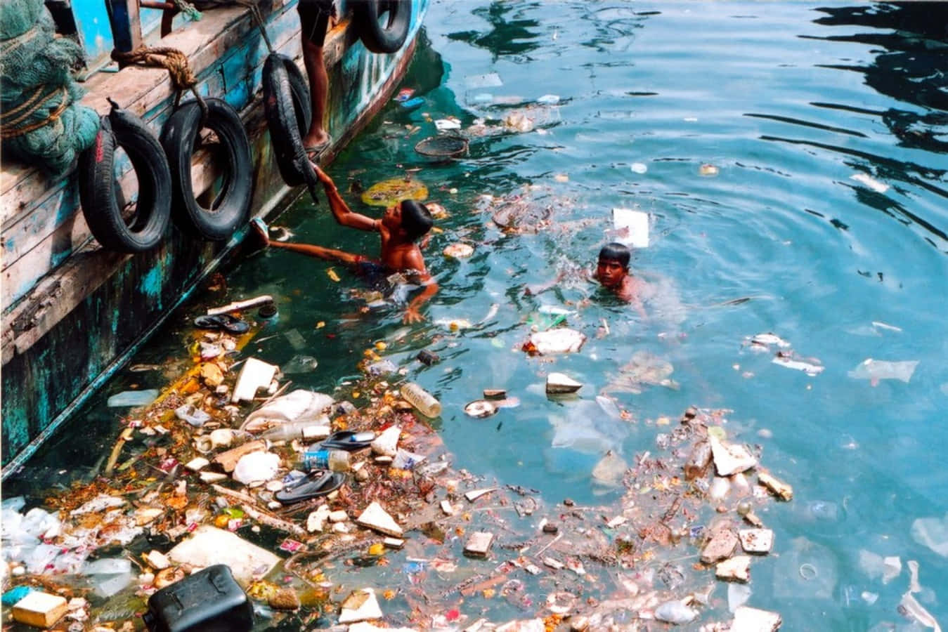 A Group Of People Swimming In The Water With Trash