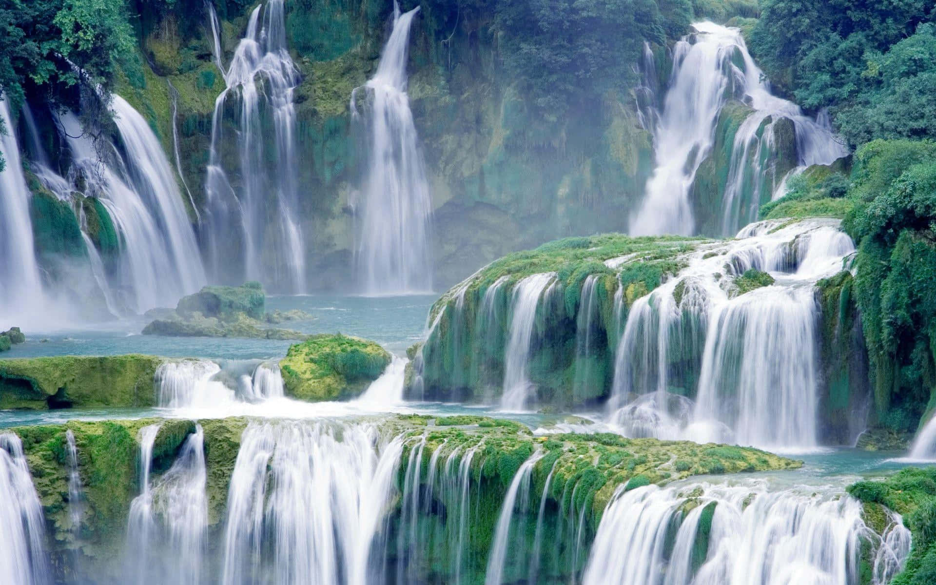Diemajestät Der Natur - Eine Atemberaubende Aussicht Auf Einen Sich Hinabstürzenden Wasserfall