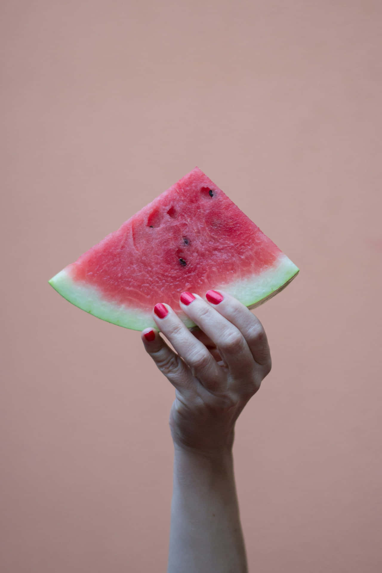 Watermelon_ Slice_ Held_ Aloft Wallpaper