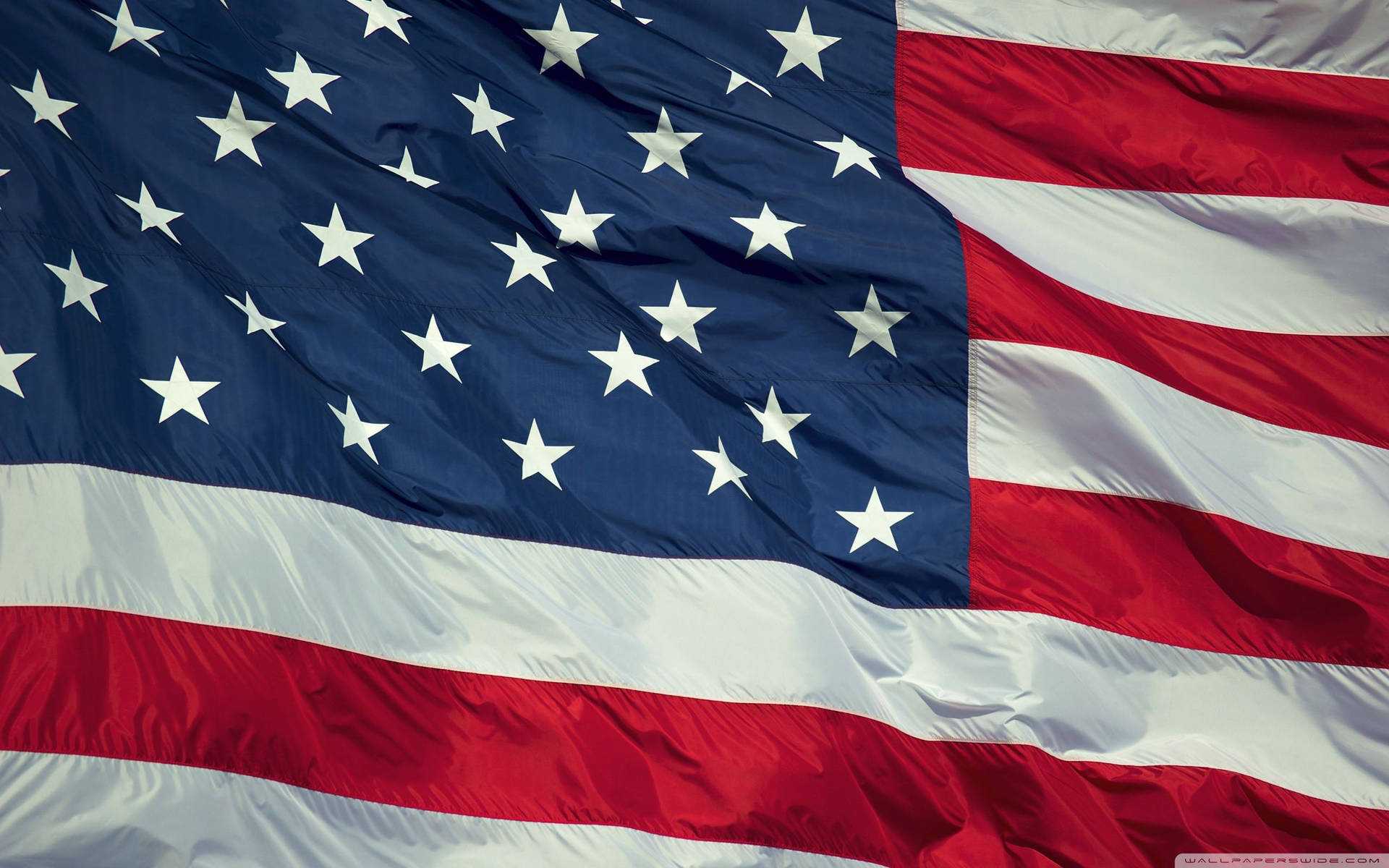 A brightly colored U.S. Flag ripples in the breeze Wallpaper