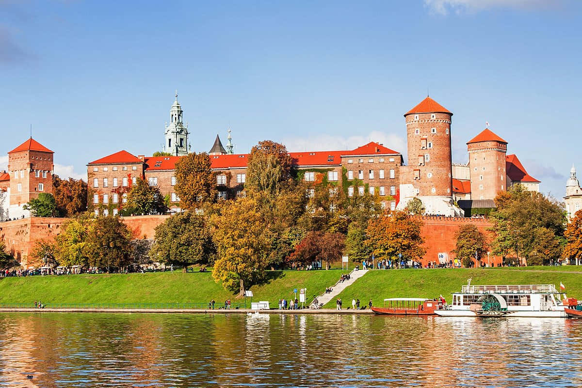 Majestic View of Wawel Castle with Parked Boats on Vistula River, Poland Wallpaper
