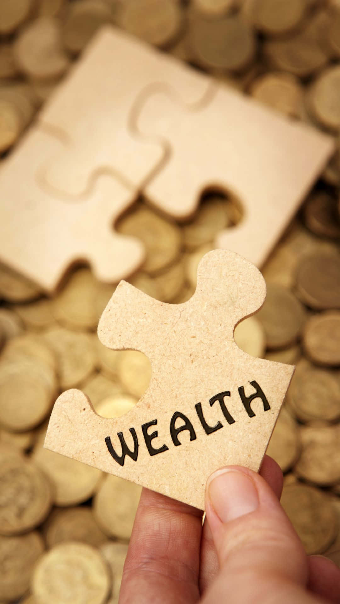 Wealth Puzzle Piece Held Over Coins Wallpaper