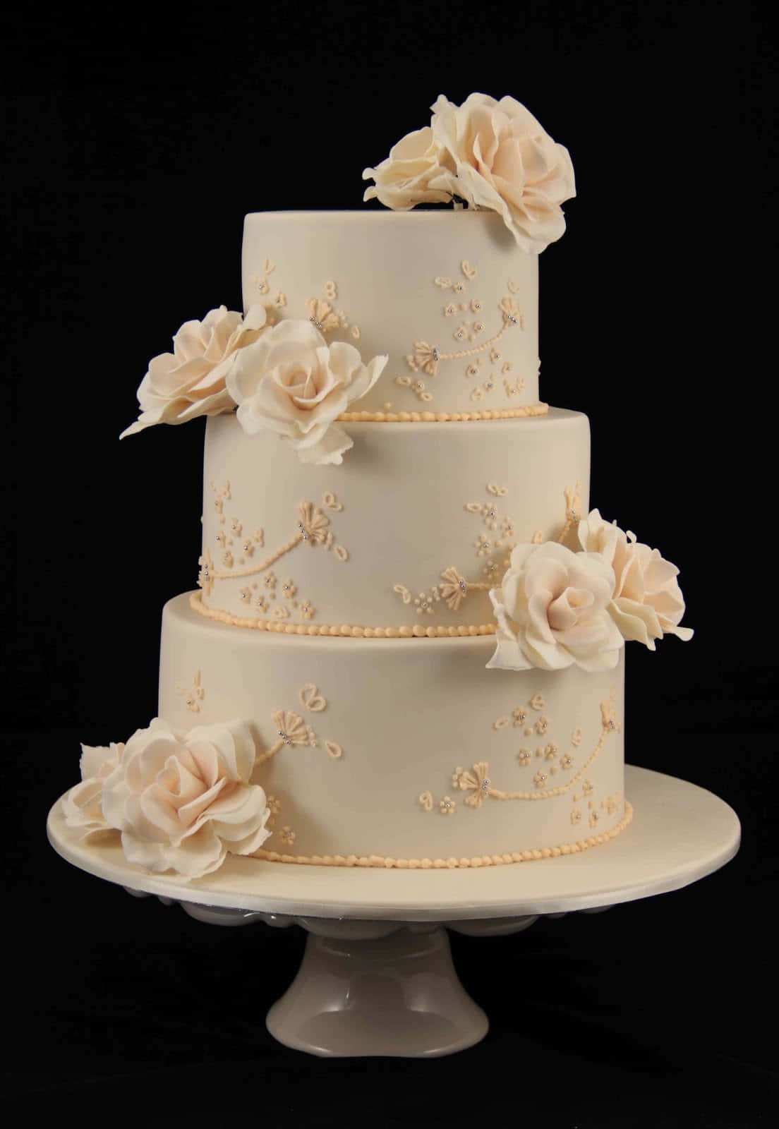 A White Wedding Cake With Cream Roses On Top