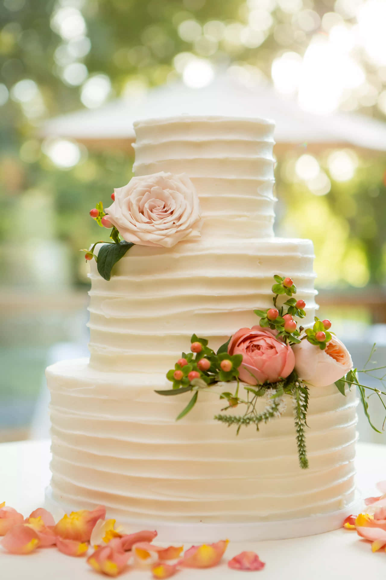 A White Wedding Cake With Flowers On Top