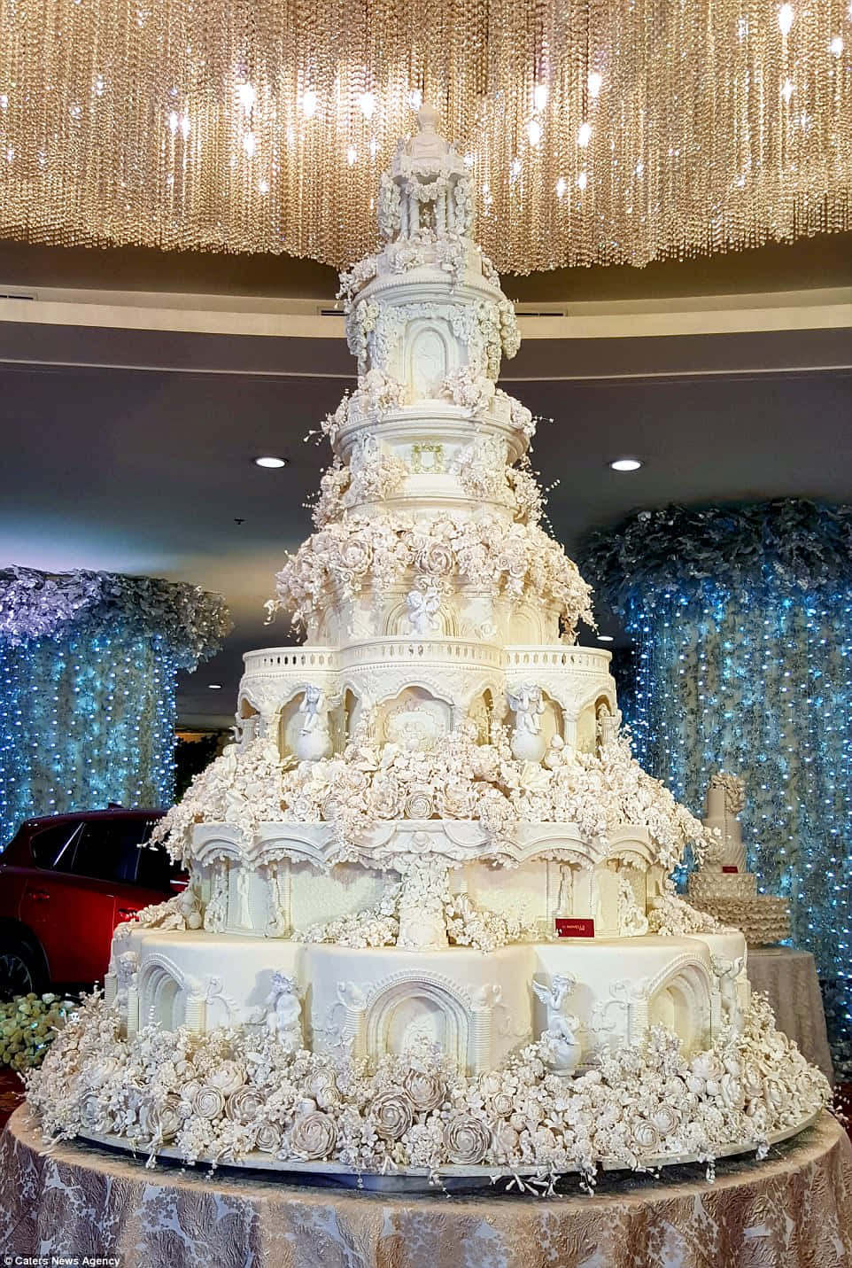 A Large White Wedding Cake Is On Display In A Room