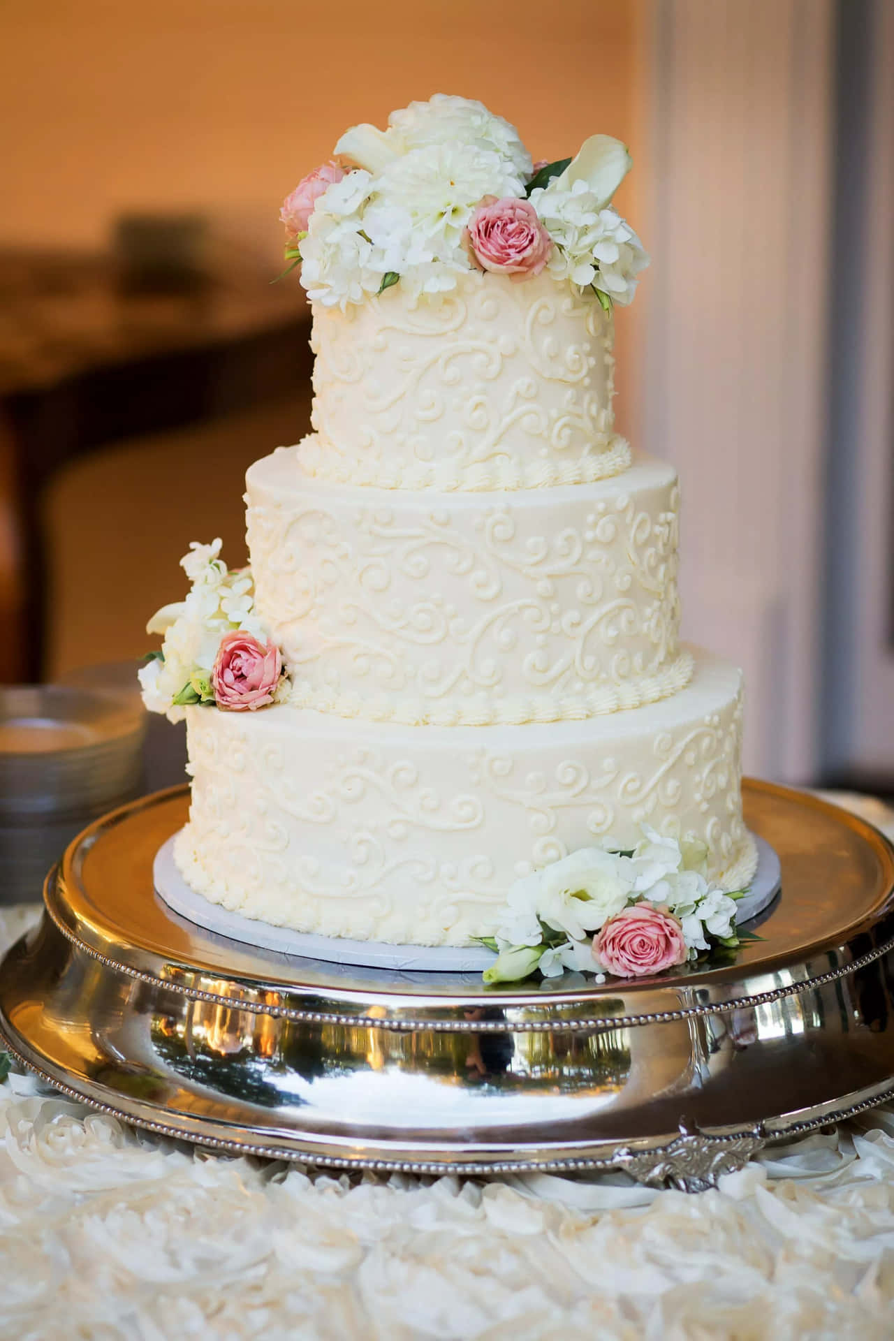 A White Wedding Cake On A Silver Plate