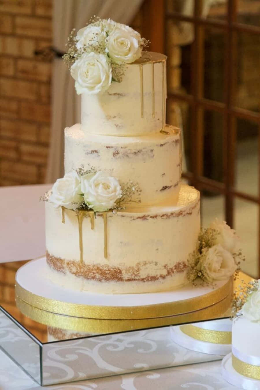 A Wedding Cake With Gold Drips And White Flowers