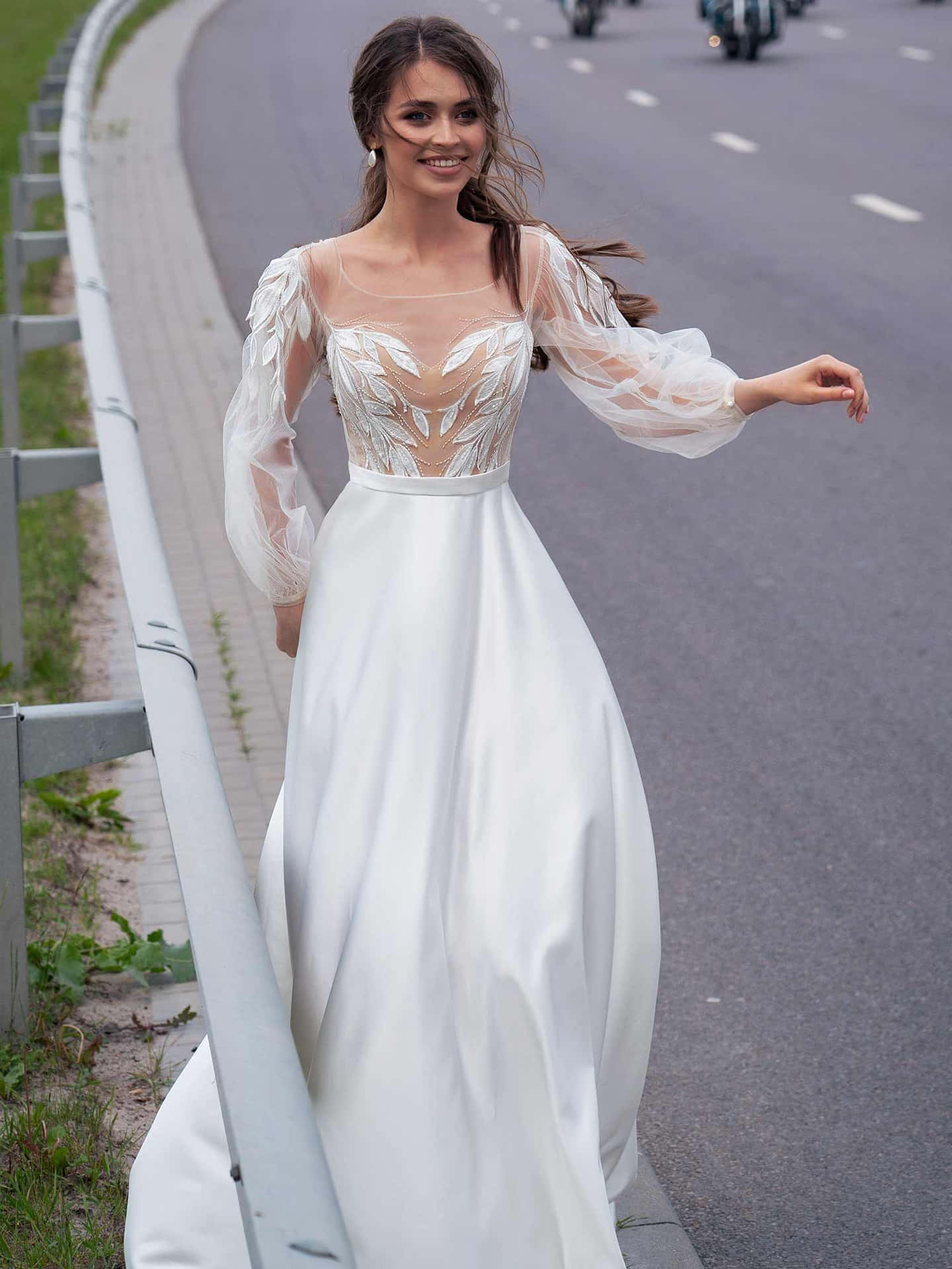 A Woman In A White Wedding Dress Is Walking Down The Road