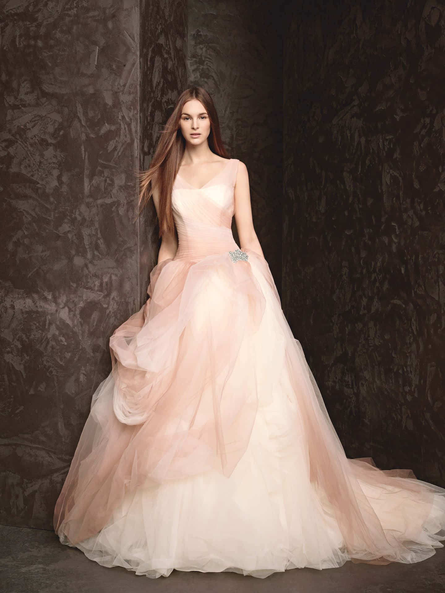 A Woman In A Pink Wedding Dress Is Posing Against A Wall