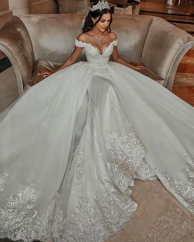 A Woman In A White Wedding Dress Sitting On A Couch