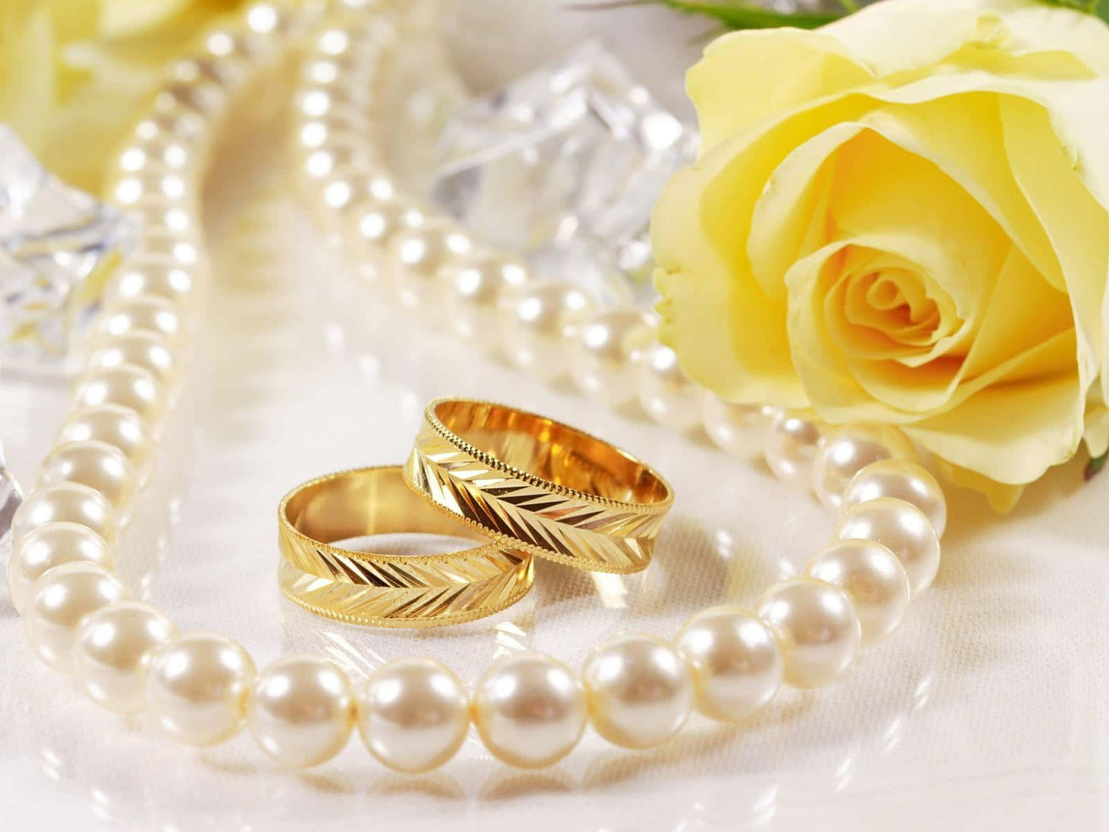 Wedding Rings And Pearls On A White Table
