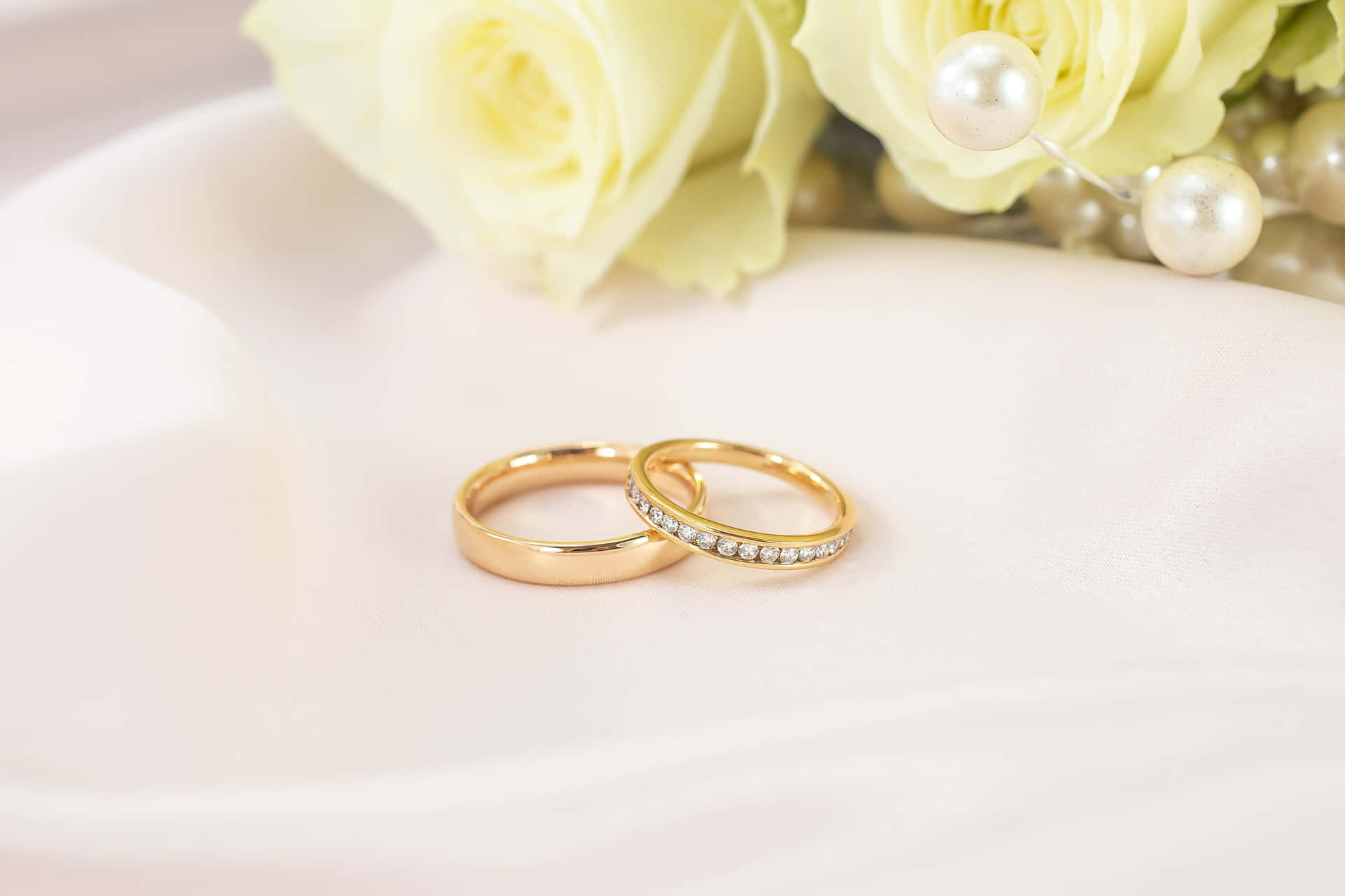 Two gold wedding rings, shining brightly in the sun.