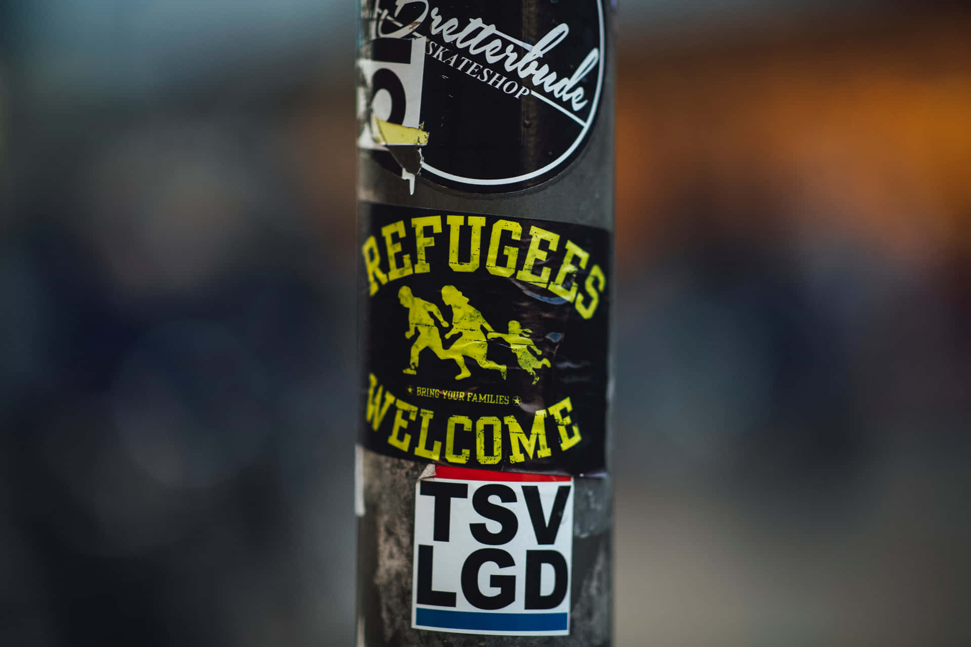 Refugees Welcome Stickers On A Pole