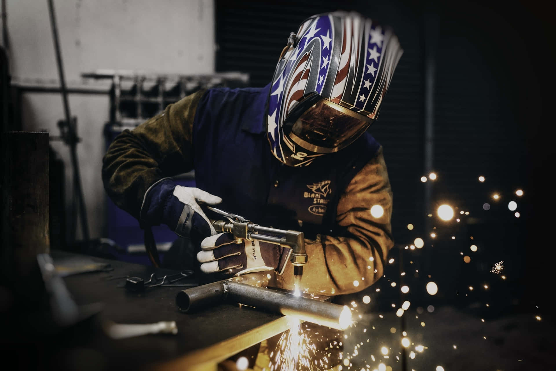 A skilled welder fabricating a metal sculpture Wallpaper