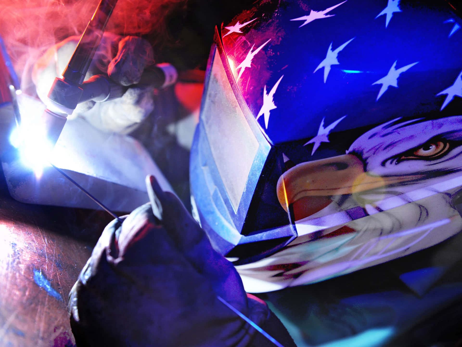 A Man Welding With An American Flag On His Helmet Wallpaper