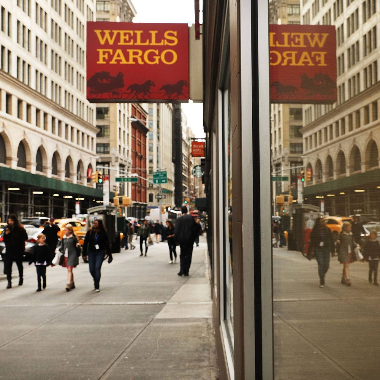 Wells Fargo bank sign on busy street with commuters Wallpaper