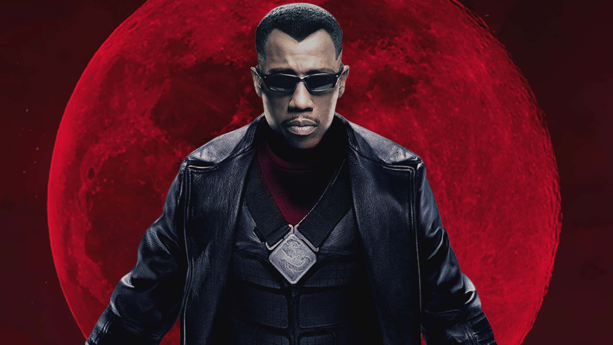 Wesley Snipes confidently posing in a black outfit and sunglasses Wallpaper