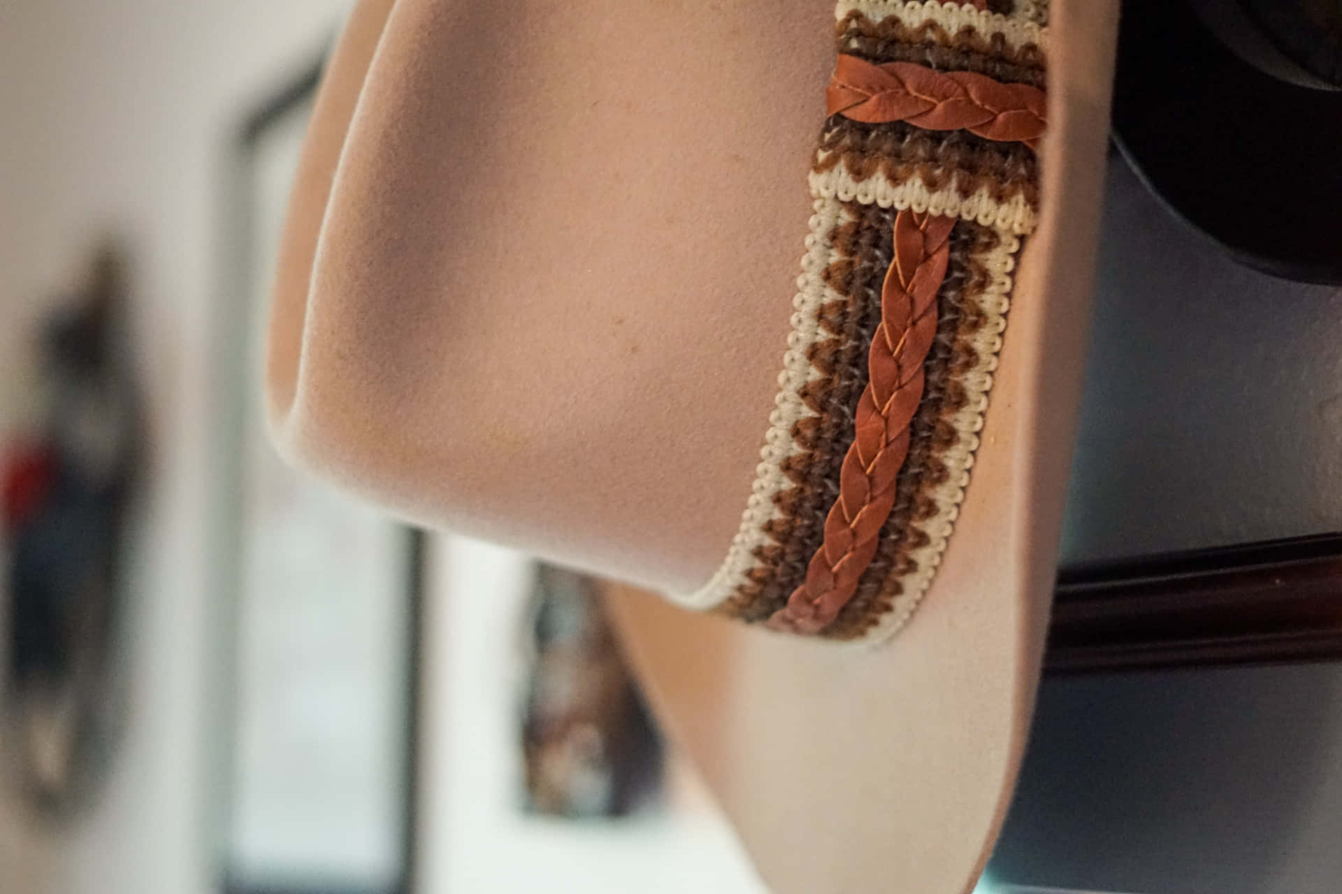 A Hat Hanging On A Wall With A Brown And Tan Band