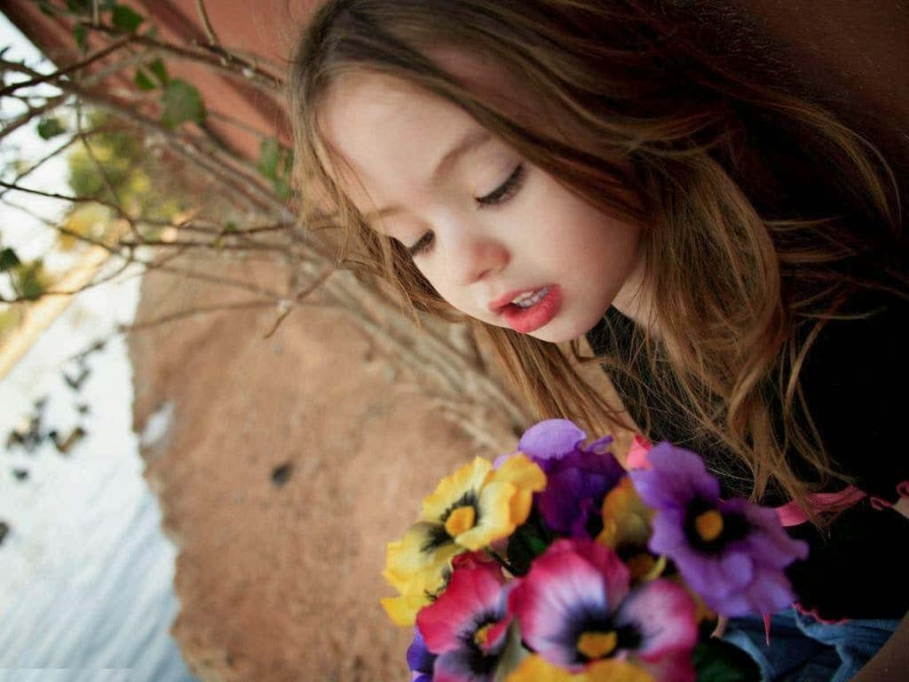 A Little Girl Holding A Bouquet Of Flowers