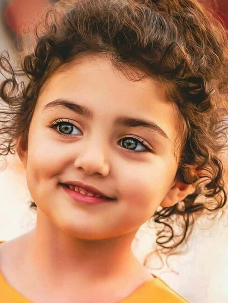 A Young Girl With Curly Hair Is Smiling