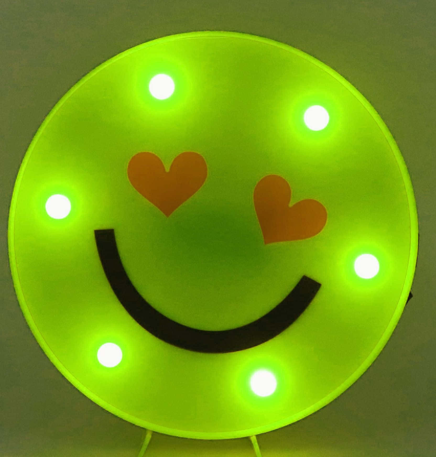 A Green Smiley Face With Lights On It