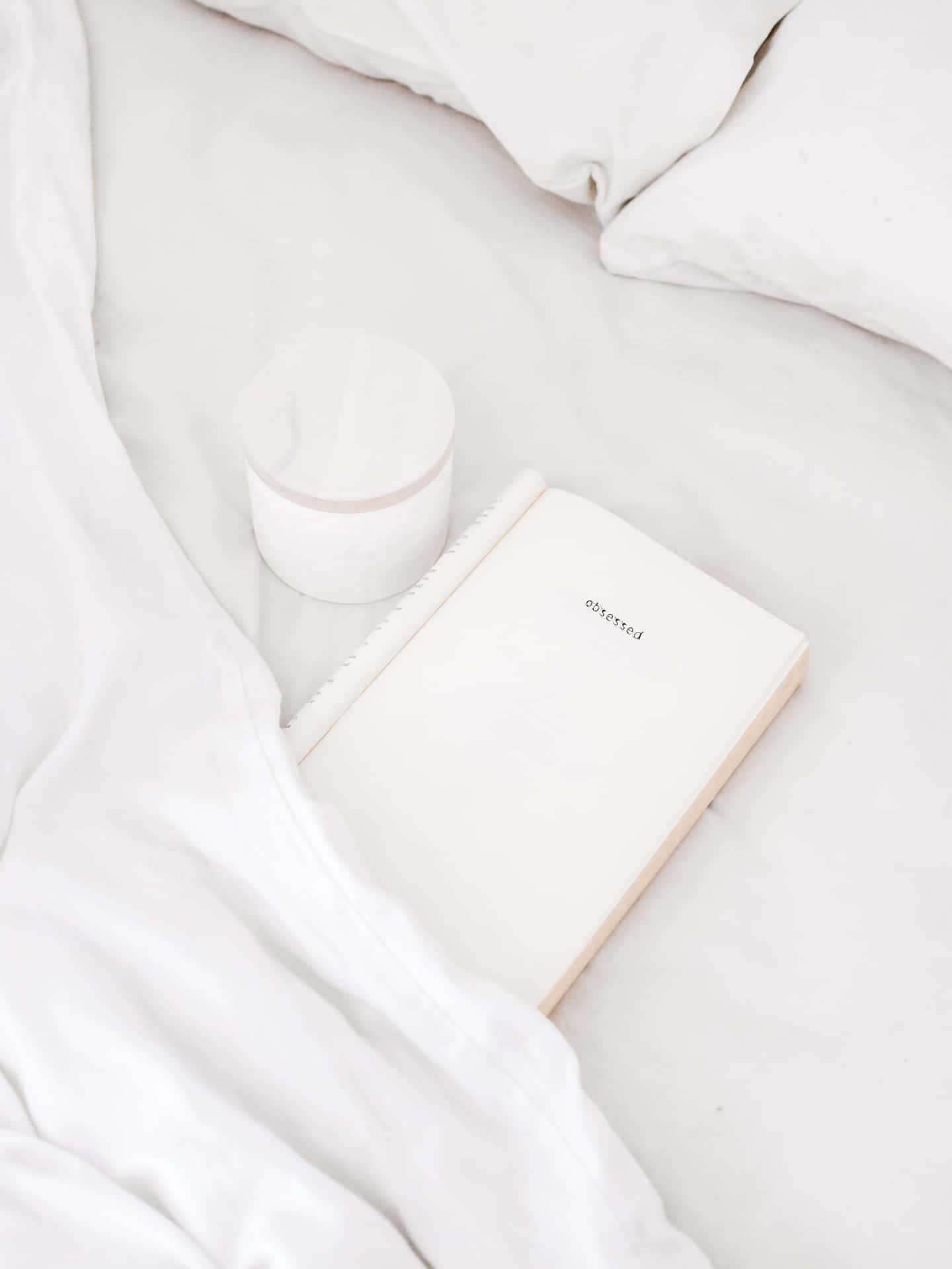 A White Notebook And A Cup Of Coffee On A Bed Wallpaper