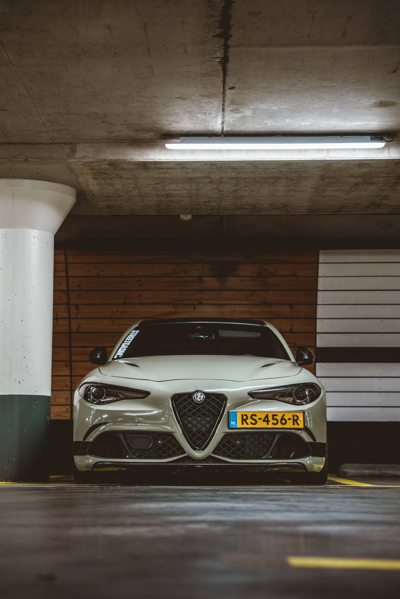 White Alfa Romeo executive car in parking lot mobile wallpaper.