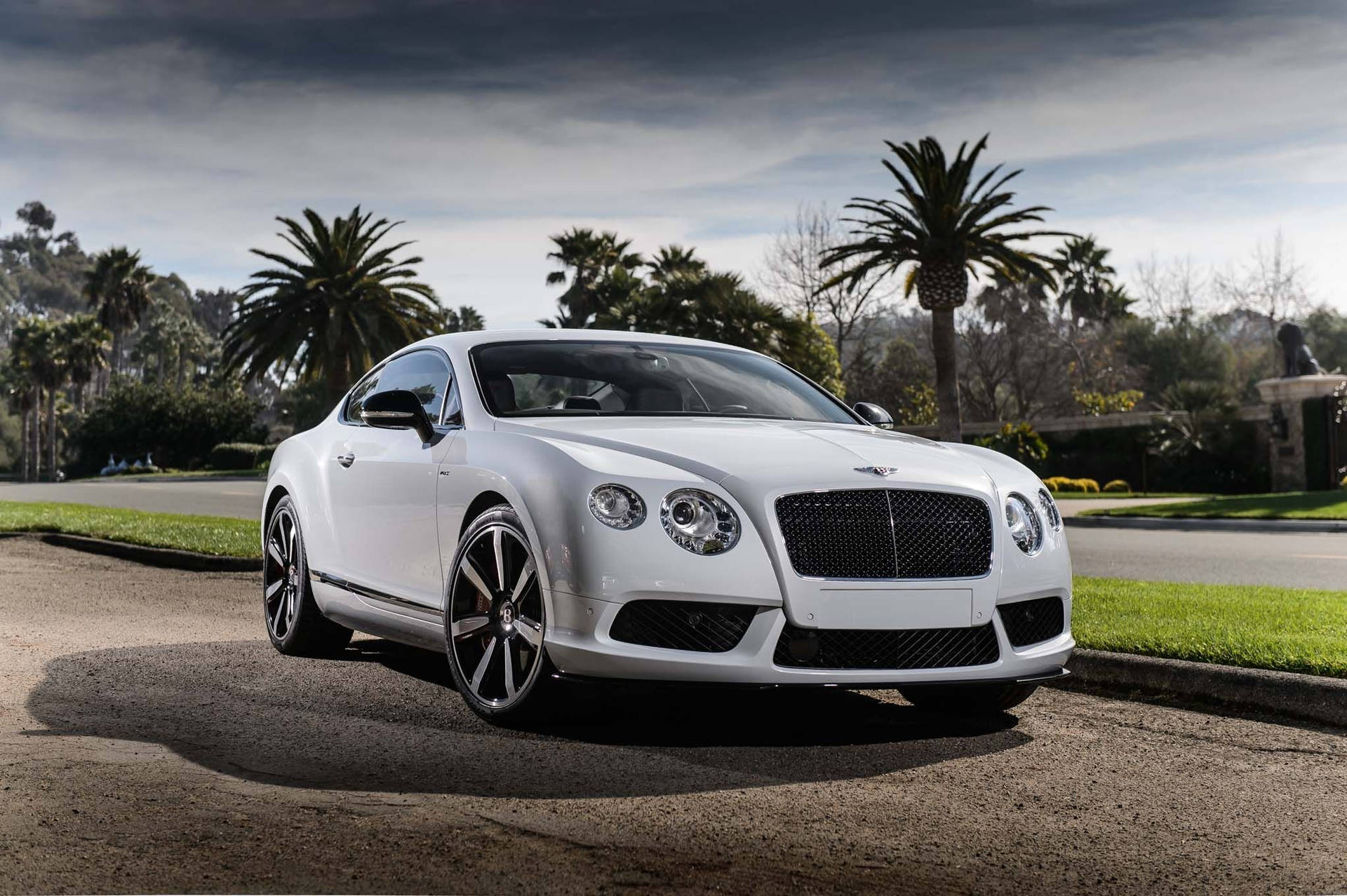 Caption: Pristine White Bentley with Shimmering Silver Rims Wallpaper