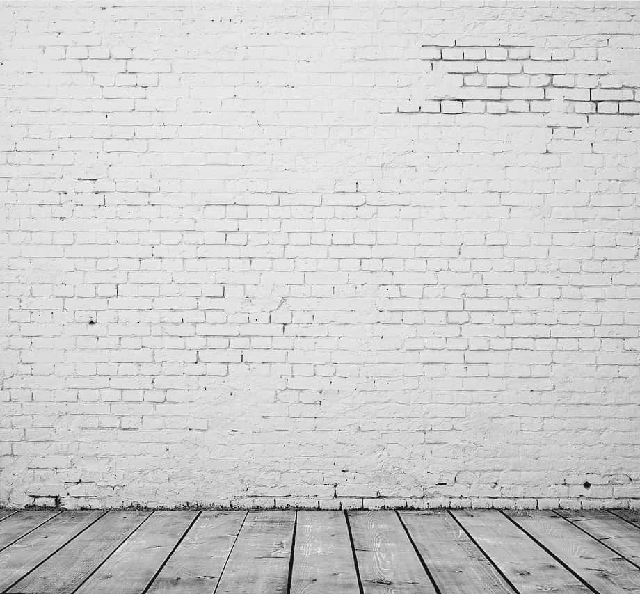 An Empty Room With A Brick Wall And Wooden Floor