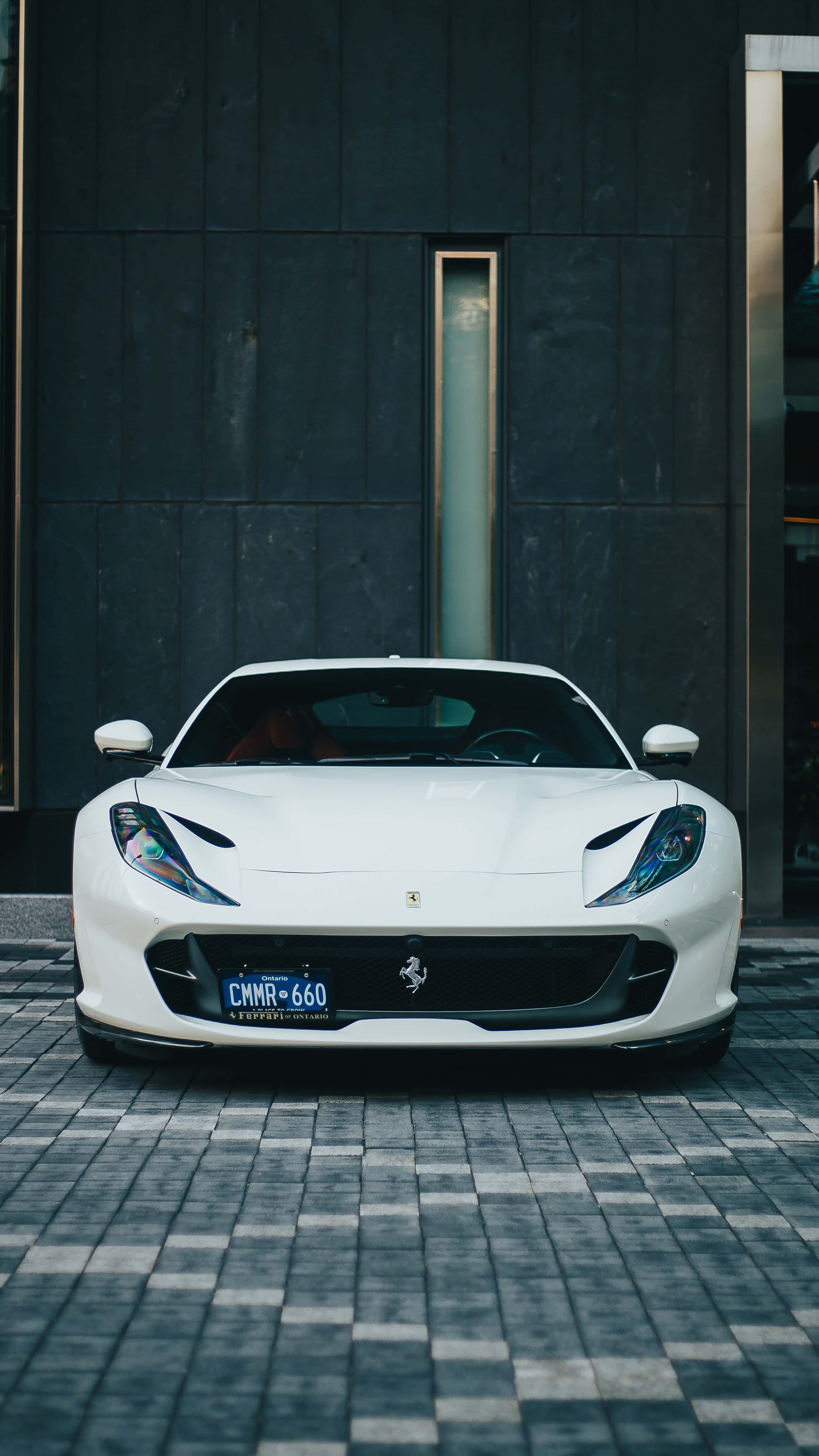A White Sports Car Parked In Front Of A Building Wallpaper