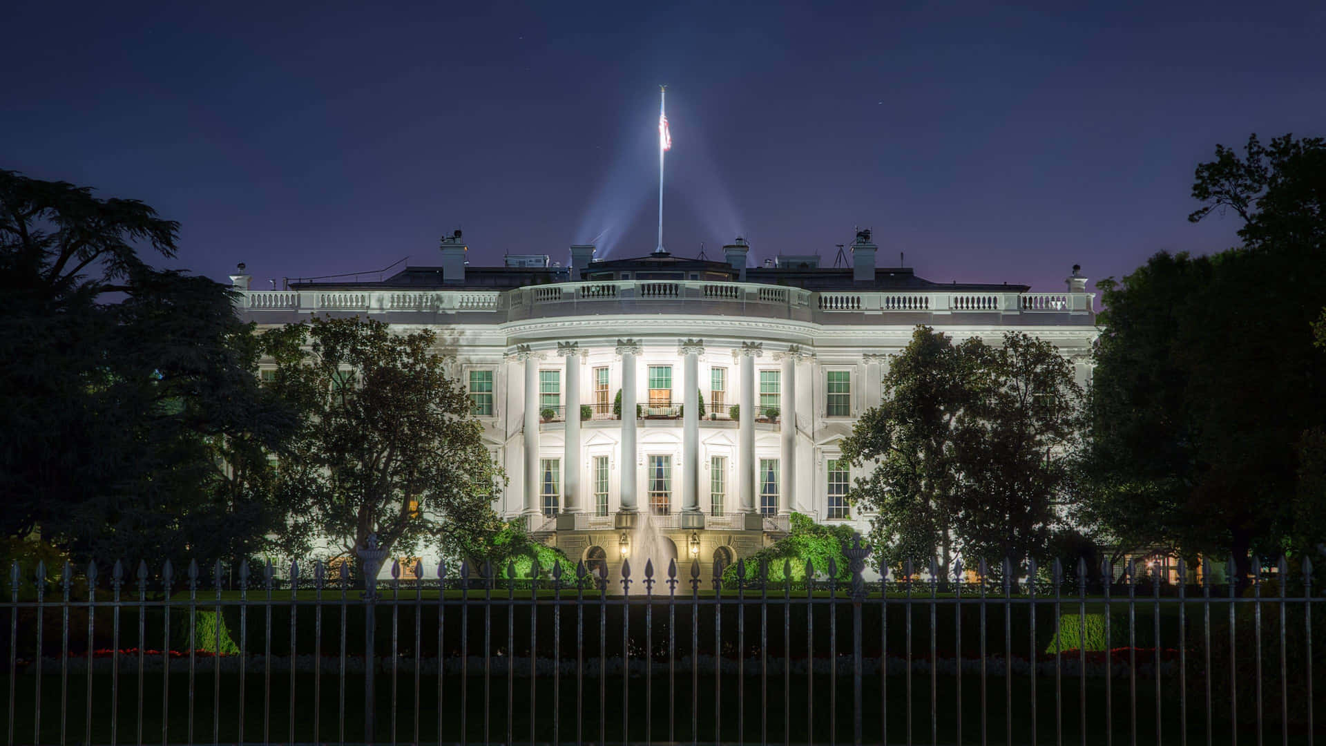 The White House At Night With A Flag