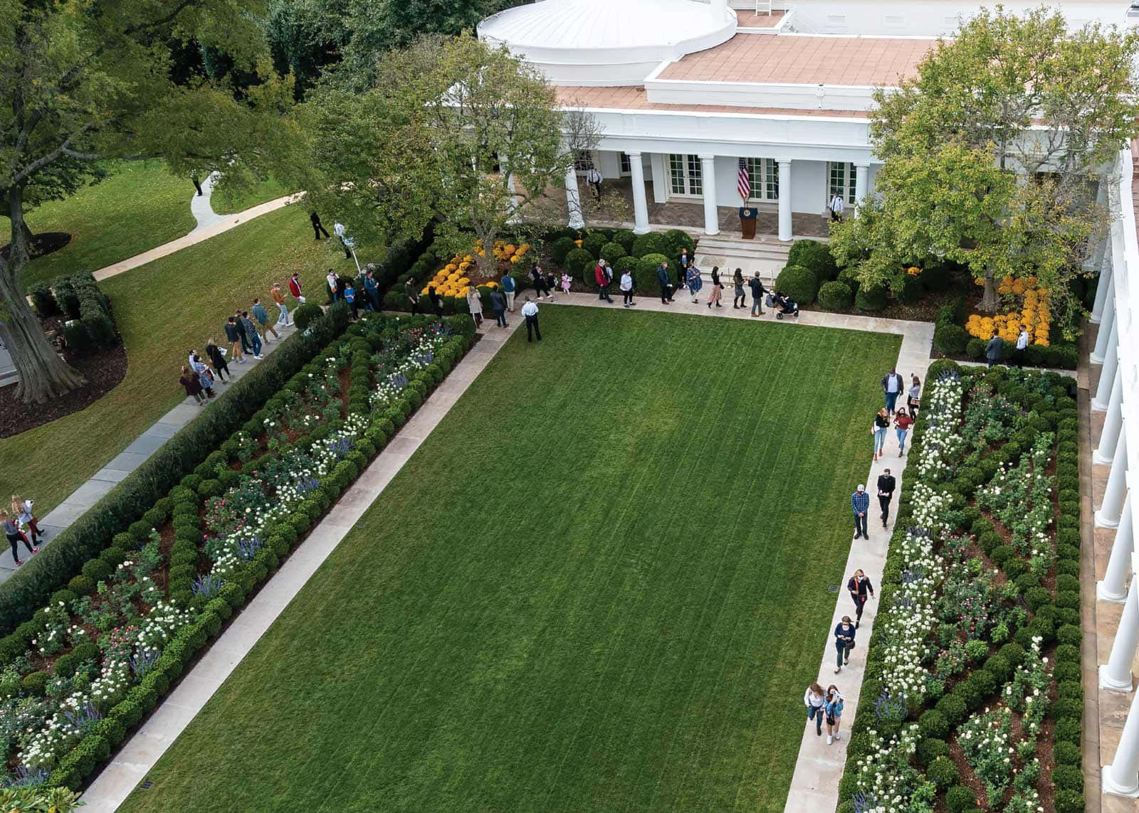 The White House Garden Is A Large Lawn With People Walking Around
